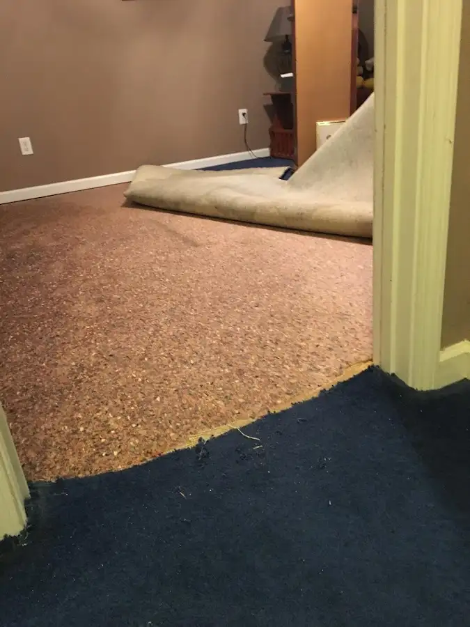 Carpet pad removal revealing water damage during Water Mitigation Services in Vicksburg